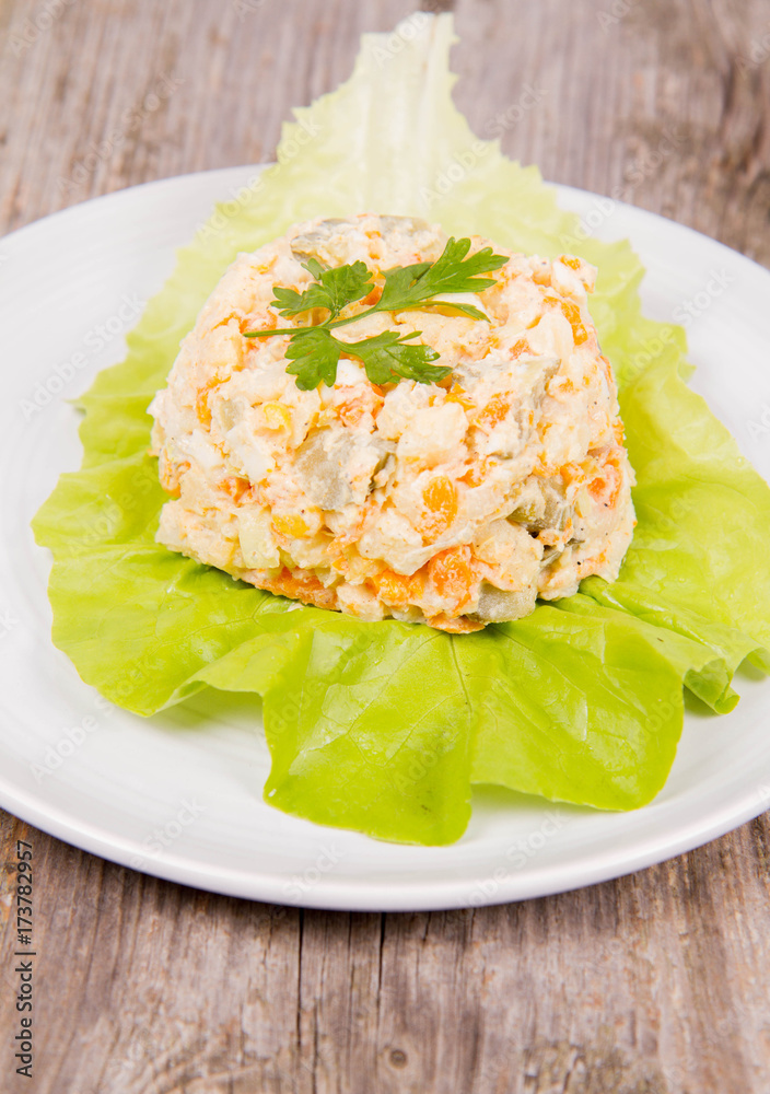 Vegetable salad (potato, carrot, corn, pea, egg, leek) with mayonnaise on a wooden background Vegetable salad (potato, carrot, corn, pea, egg, leek) with mayonnaise on a wooden background