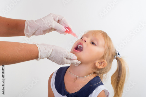 little girl on reception at the doctor receives the polio vaccine, a child being treated for influenza, the child takes the medicine in the hospitalception at the doctor takes antipyretic, anti-flu,