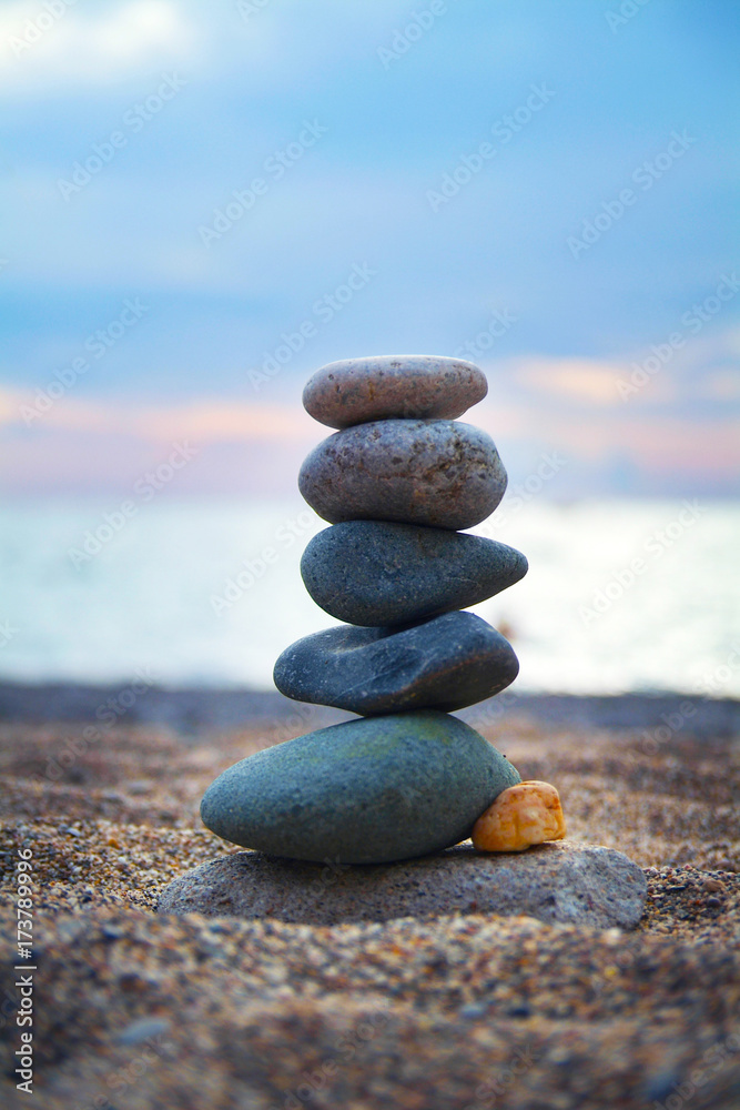 Stones laid out in the form of a pyramid on the seashore. Vertical frame. Close-up view Stones laid out in the form of a pyramid on the seashore. Vertical frame. Close-up view
