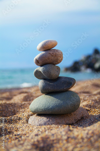 Stones laid out in the form of a pyramid on the seashore. Vertical frame. Close-up view
