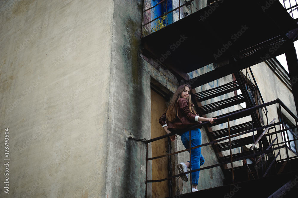 street portrait of a female student in fashionable clothes, blue jeans and a brown jacket, outdoors street portrait of a female student in fashionable clothes, blue jeans and a brown jacket, outdoors