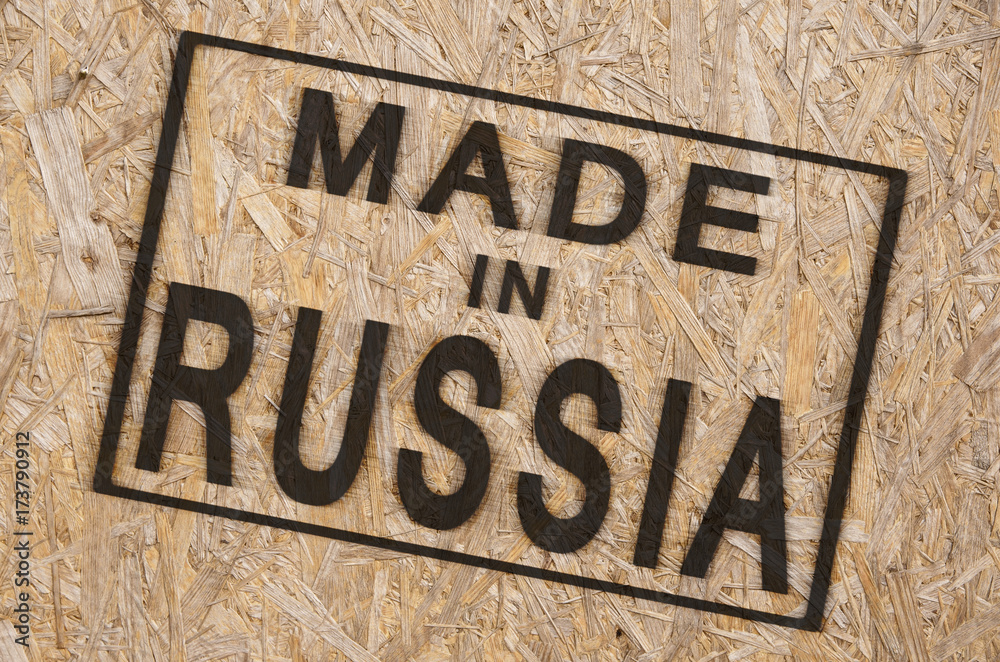 close-up of a brown pressed wood textured box with burn stamp Made in Russia on it close-up of a brown pressed wood textured box with burn stamp Made in Russia on it