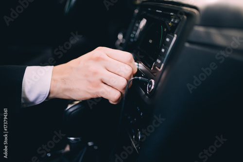 Businessman in a business suit in the car changes gear