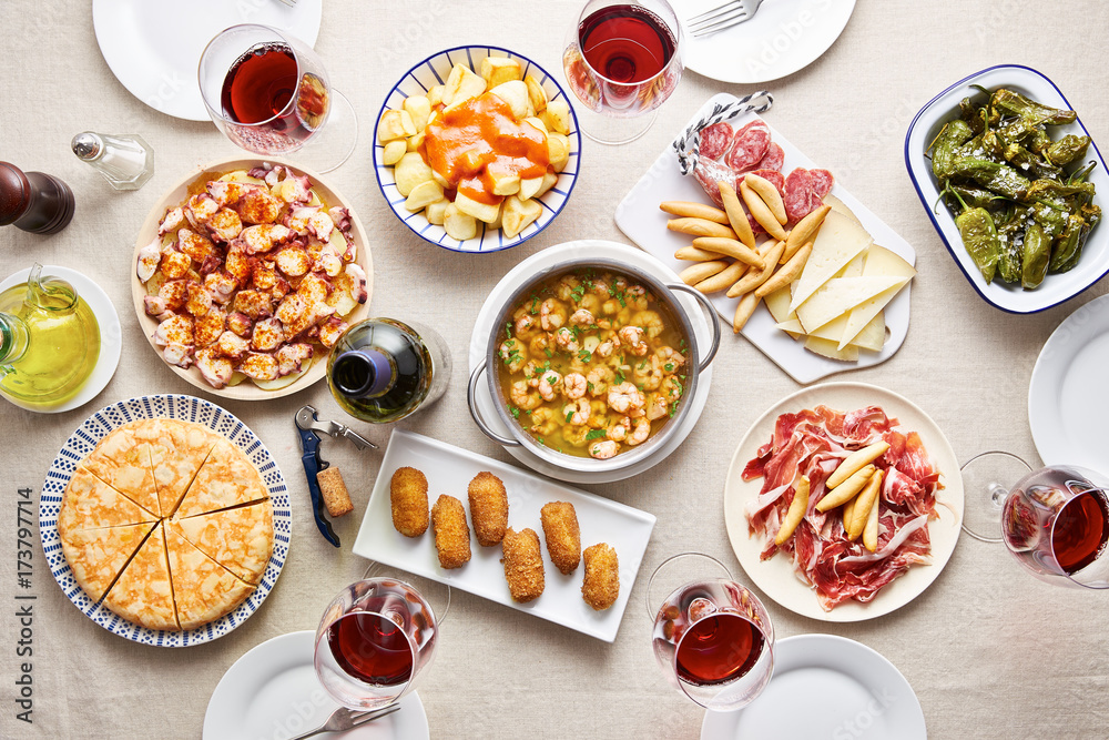 Spanish tapas with variety of dishes on white table Spanish tapas with variety of dishes on white table