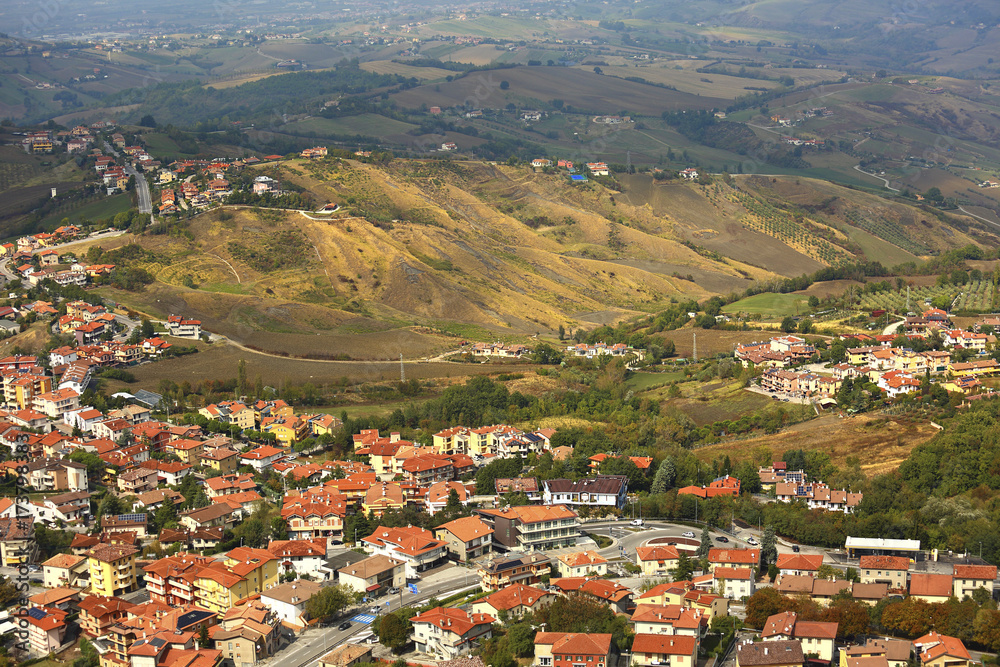 Beautiful landscape of mountains and rural town under blue sky from high view of San Marino city