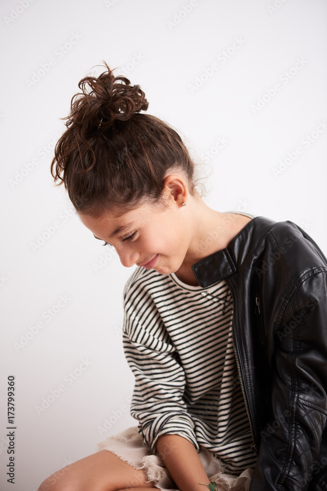 Cute teen girl in stripe pullover and leather jacket smiling down Cute teen girl in stripe pullover and leather jacket smiling down