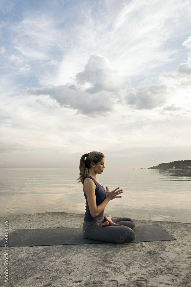 Side view of girl pressing hands in lotus pose Side view of girl pressing hands in lotus pose