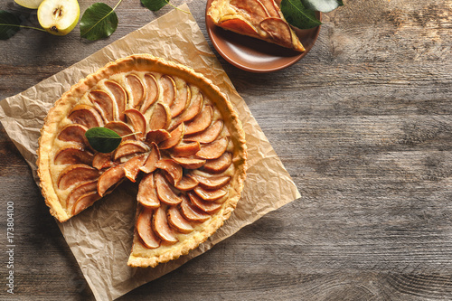 Delicious pear tart on wooden background