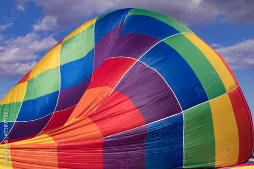 Colorful hotair balloon against blue sky with clouds