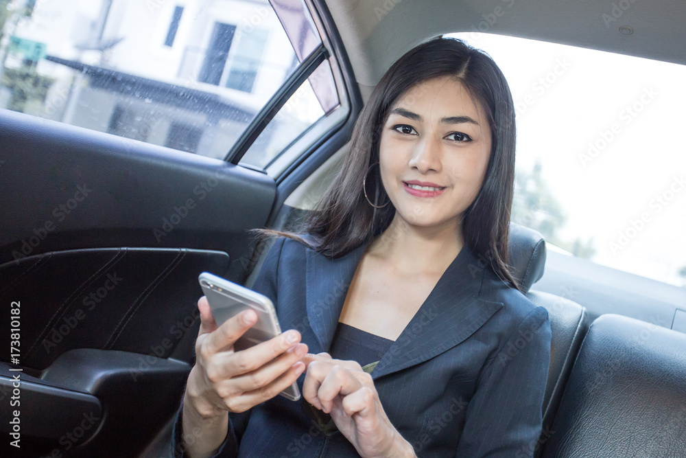 Woman using Smartphone for working in car with attractive smiling, Woman working concept.