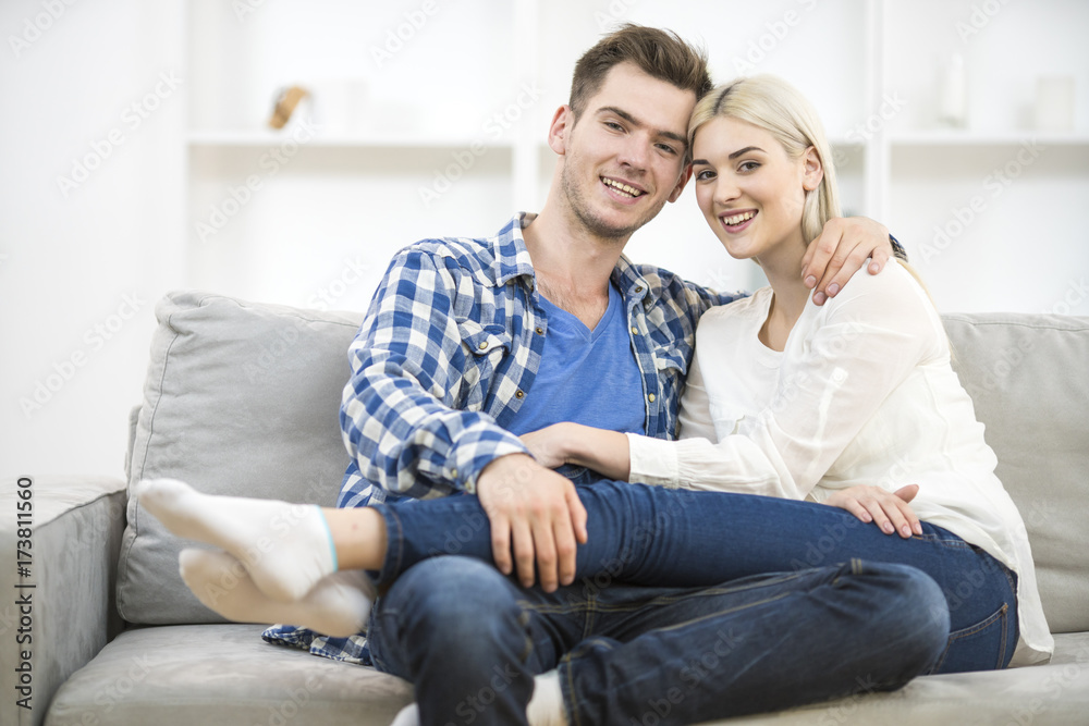 The happy man and woman sit on the sofa