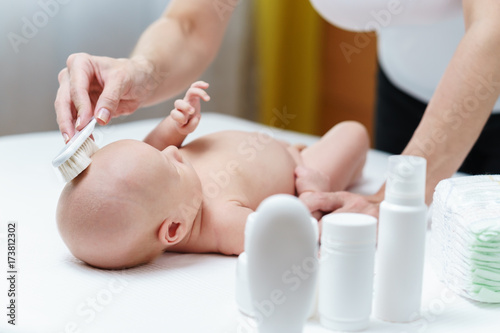 Mom clean baby skin on the head by soft brush for skin care