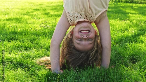 Happy child playing on green grass outdoors in spring park