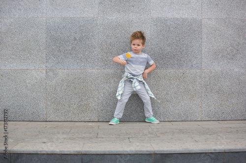 Fashion kid near gray wall