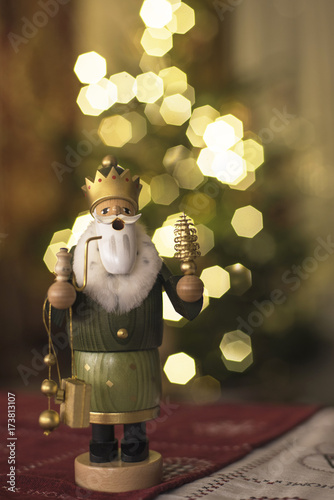 Traditional wooden incense figure in front of the Christmas tree
