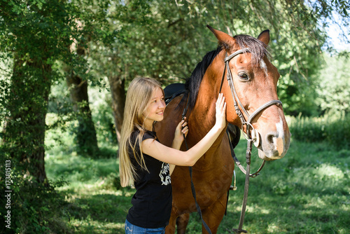Beautiful girl gently hugs her friend - brown horse