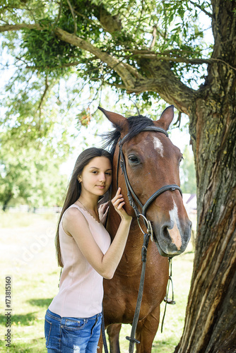 Beautiful girl gently hugs her friend - brown horse