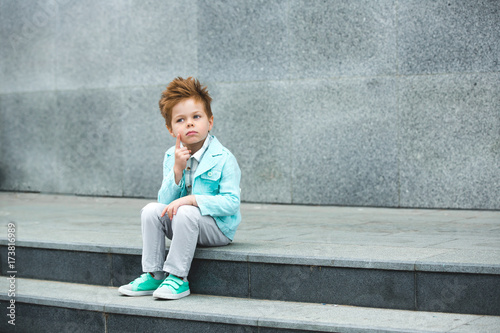 Fashion kid posing near gray wall © Kirill Grekov
