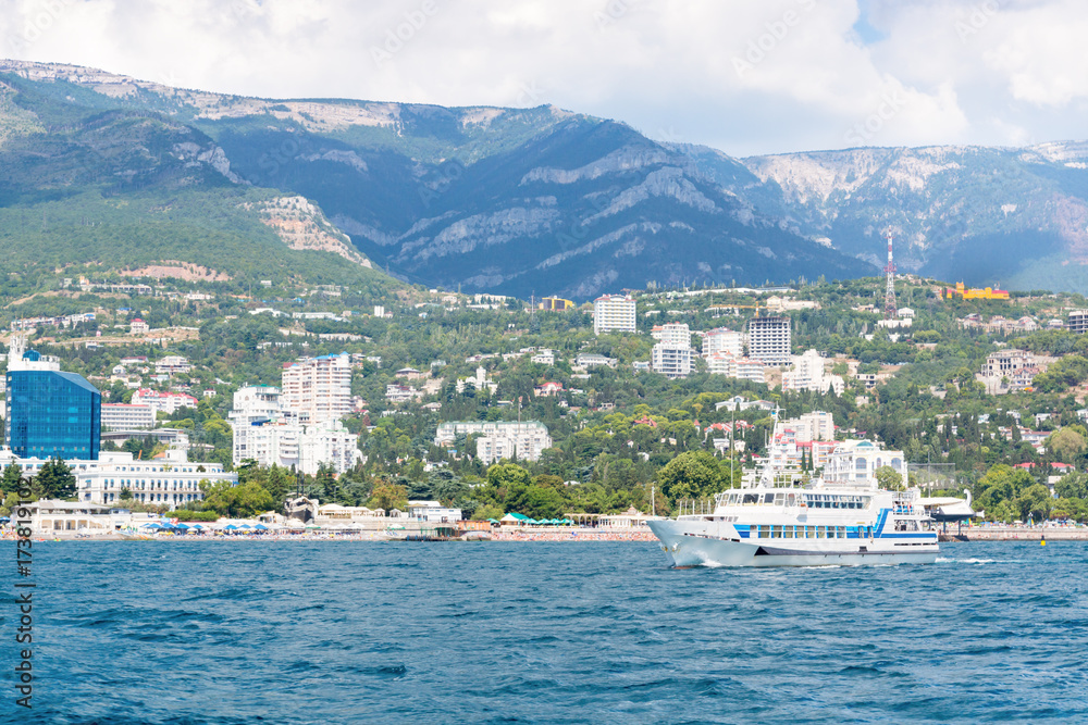 Views of the Crimean coastline with hotels and beaches with mountains in the background.