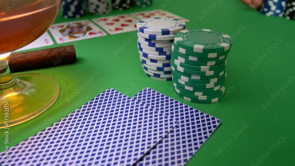 Winner In Poker. Poker Players Wins And Takes The Money. Royal Flush, Cigar and Glass with Brandy On The Green Table With Poker Chips. Man Moves Chips on Table at Casino Winner In Poker. Poker Players Wins And Takes The Money. Royal Flush, Cigar and Glass with Brandy On The Green Table With Poker Chips. Man Moves Chips on Table at Casino