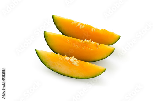 Three cut pieces of ripe yellow melon. With seeds. Isolated on white background