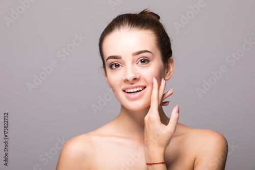 Studio portrait of a beautiful young woman with brown hair. Pretty model girl with perfect fresh clean skin. Beauty and skin care concept