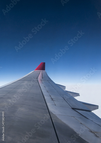 wing of airplane from Air in the sky winglet red colored airline blue sky clouds