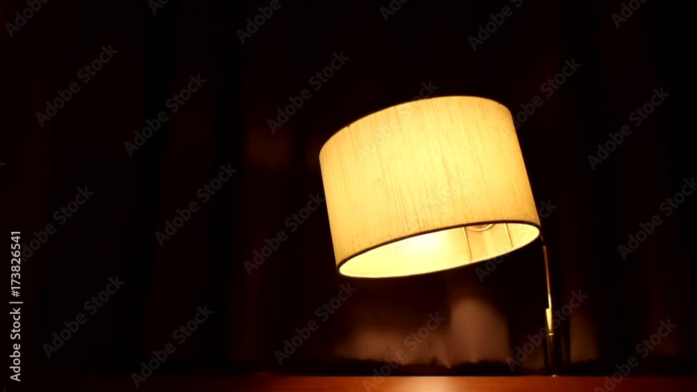 Nostalgic room in the old hotel. The old lamp shining at retro radio. Vintage bedroom with radio and a table lamp above the bed.