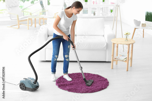 Woman cleaning small rug wi...