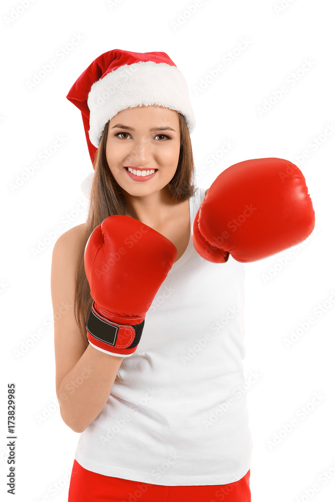 Beautiful young woman in Santa Claus hat and boxing gloves on white background. Boxing Day concept Beautiful young woman in Santa Claus hat and boxing gloves on white background. Boxing Day concept