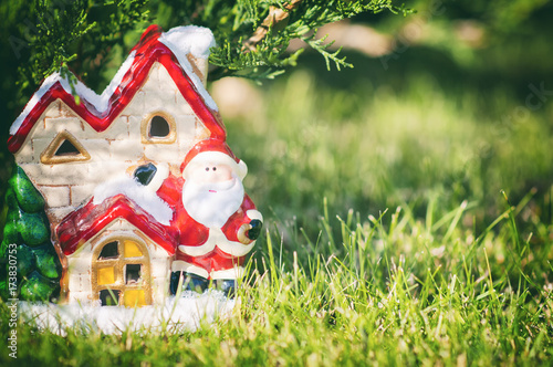 New Year Winter Composition. Santa's house, toy Santa under the tree