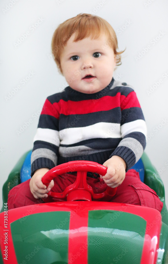 Portrait of cute little boy one year old with ginger hair and blue eyes