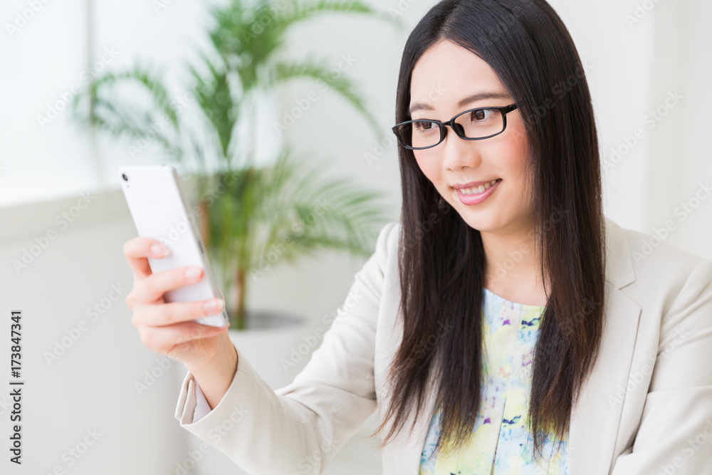 スマートフォンを見る女性 ビジネス スマートフォンを見る女性 ビジネス