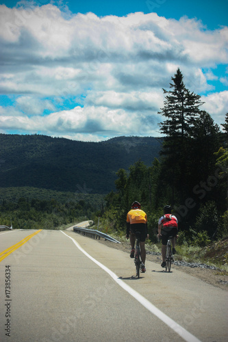 2 people cycling on a endless road in the mountains