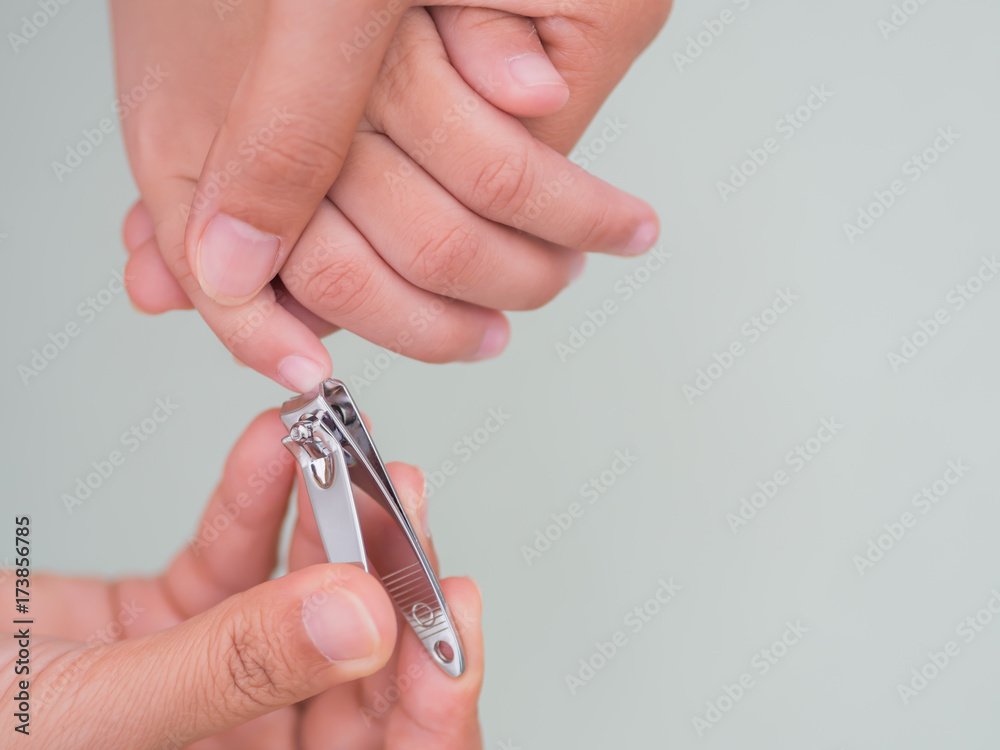Family activity mother hand cut nails for kid by using nail clipper, with selective focus. Family activity mother hand cut nails for kid by using nail clipper, with selective focus.