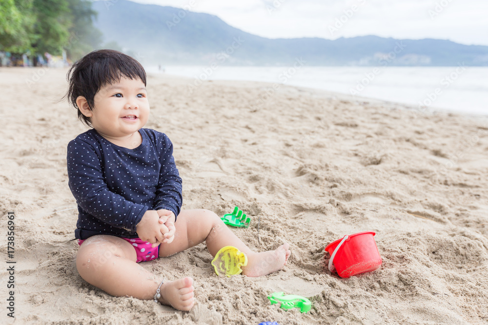 Adorable cute girl smile and happy face for playing on the beach.
