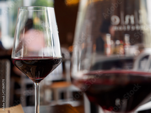 Obraz na plátně Close-up macro detail of a pair of red wine glasses, with foreground blur, at an expensive Italian restaurant