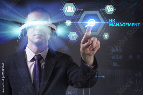 Business, Technology, Internet and network concept. Young businessman working in virtual reality glasses sees the inscription: HR management