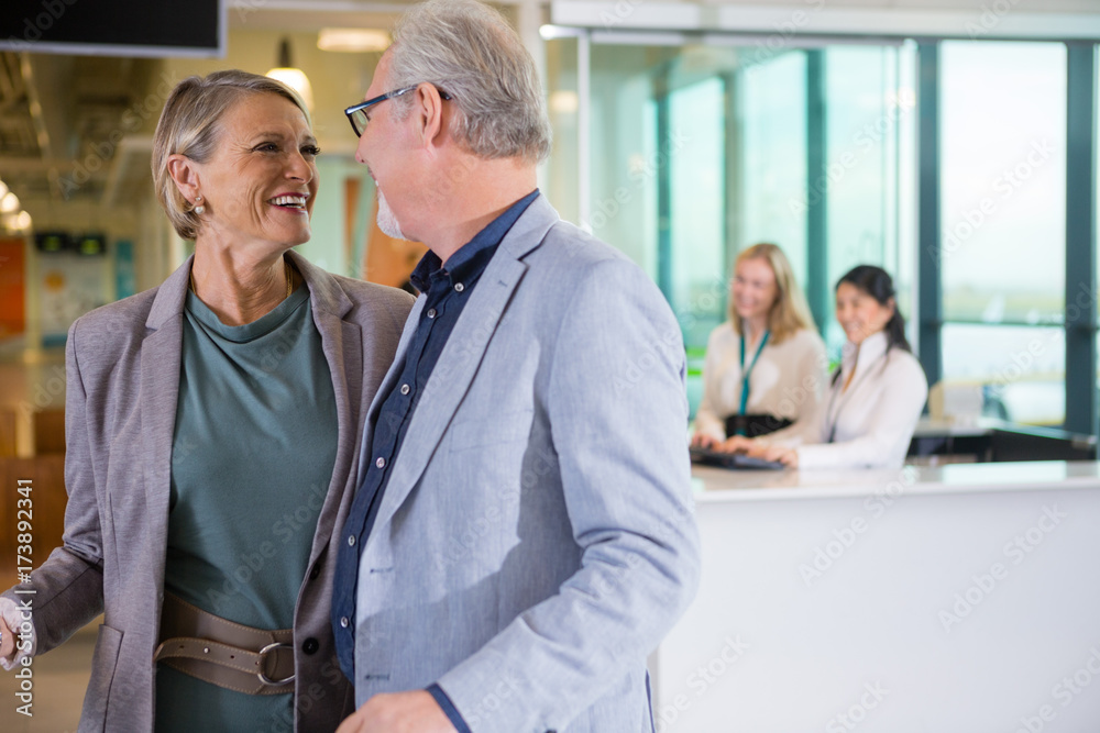 Obraz premium Smiling Business Couple Looking At Each Other In Airport