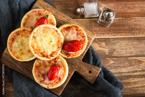 Italian homemade mini pizza with cheese, tomatoes. Dark background. photo