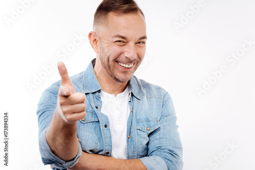 Handsome man smiling and pointing at camera with finger