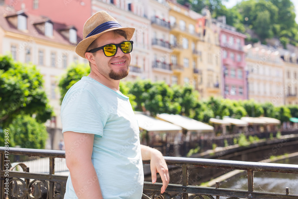 Young handsome man in old european town. Traveler, summer, people and journey concept