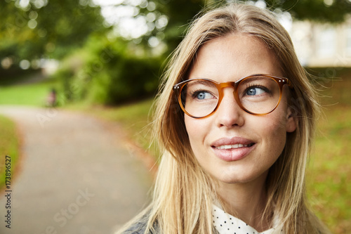Beautiful blue eyed blond in glasses in park