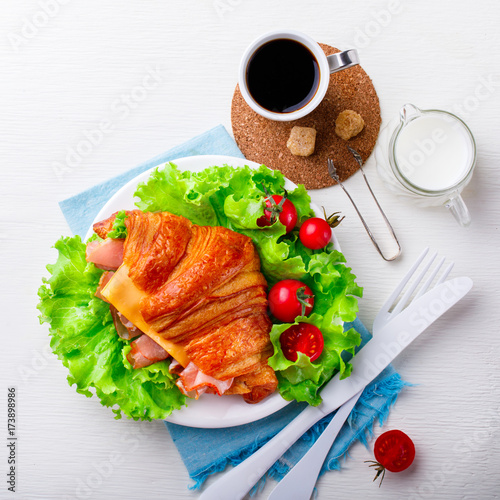 Fresh Croissant Sandwich with Ham, Cheese,Cherry tomatoes and Salad leaf with Coffee with Milk Breakfast Delicious Baking Light Meal