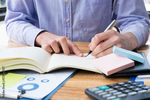 businessman write note on notebook at office desk. man write memo with fountain pen at workplace.