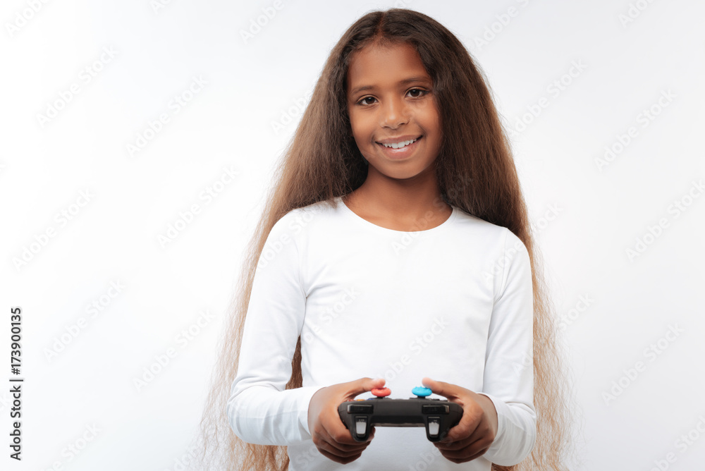 Pleasant pre-teen girl holding video game controller Stock Photo | Adobe  Stock