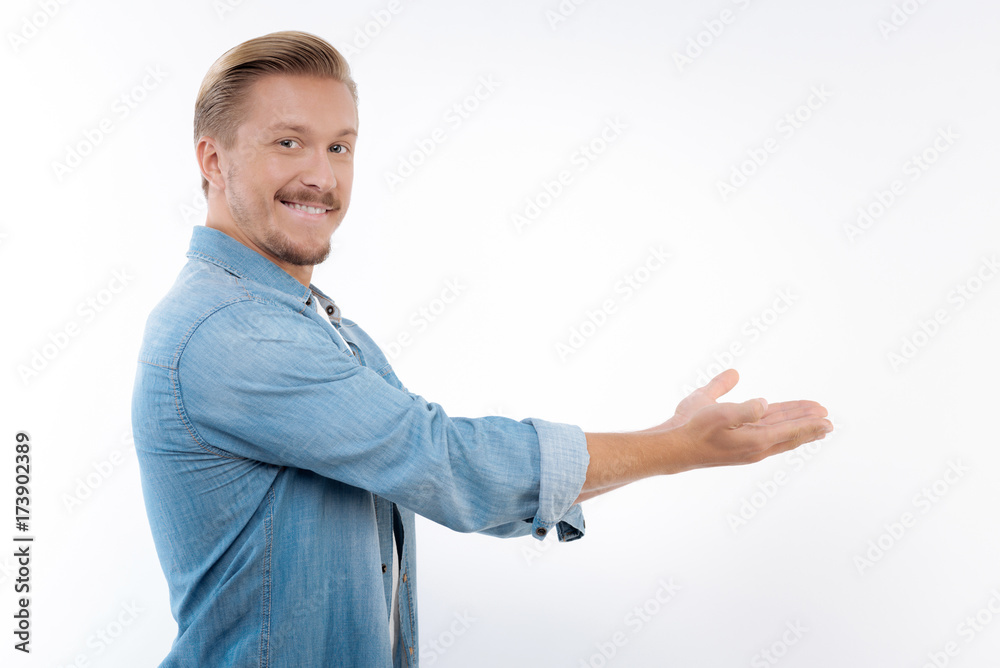 Cheerful man pointing at something with both hands Cheerful man pointing at something with both hands
