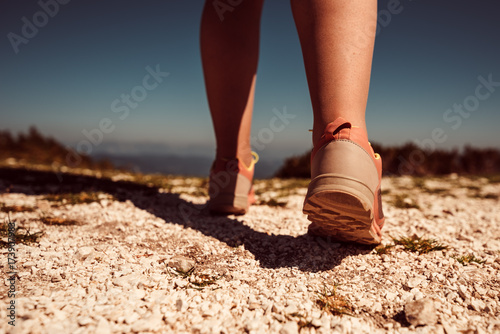 Female athlete running on mountain rocky path