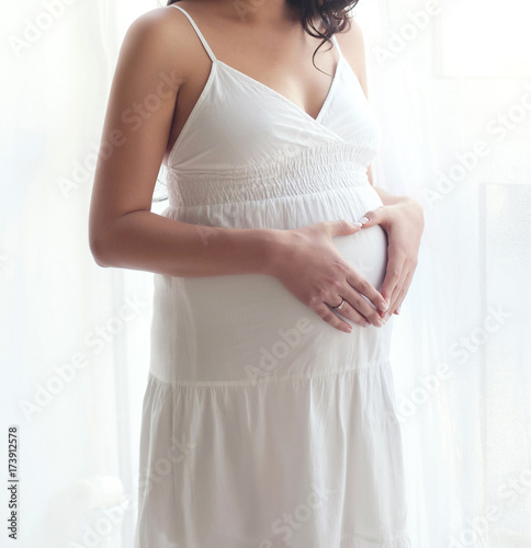 Happy pregnant woman heart symbol love touching tummy