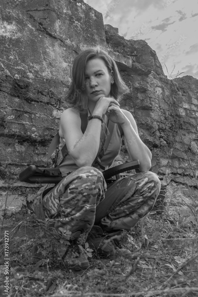 Fototapeta premium black and white, girl with arms sitting against the wall.